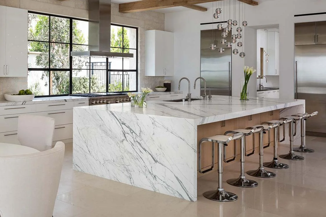 Bright contemporary island with a white waterfall surface, timber cabinetry and seating